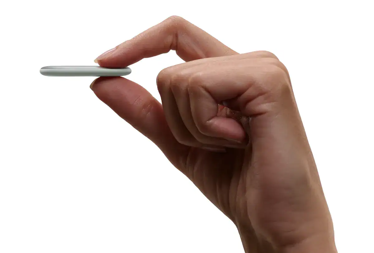 Google Pixel Tag: Googles erster eigener Bluetooth-Tracker mit UWB 7 Eine Hand hält den dünnen, ovalen Google Pixel Tag zwischen zwei Fingern
